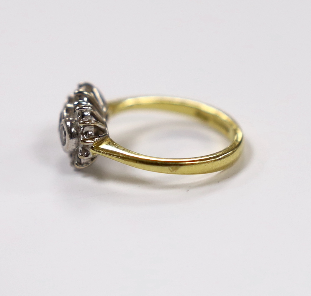 A modern 18ct gold and collet set three stone diamond ring, with diamond chip set border, size J/K, gross weight 4.6 grams.